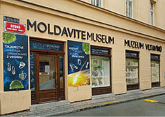 Fas da muzea Moldavite a Muzeum Vltav no s n pisy a v lohami zobrazuj c mi drahokamy a vesm rn motivy v historick  budov  na ulici Rybn .  Popis generovan  AI