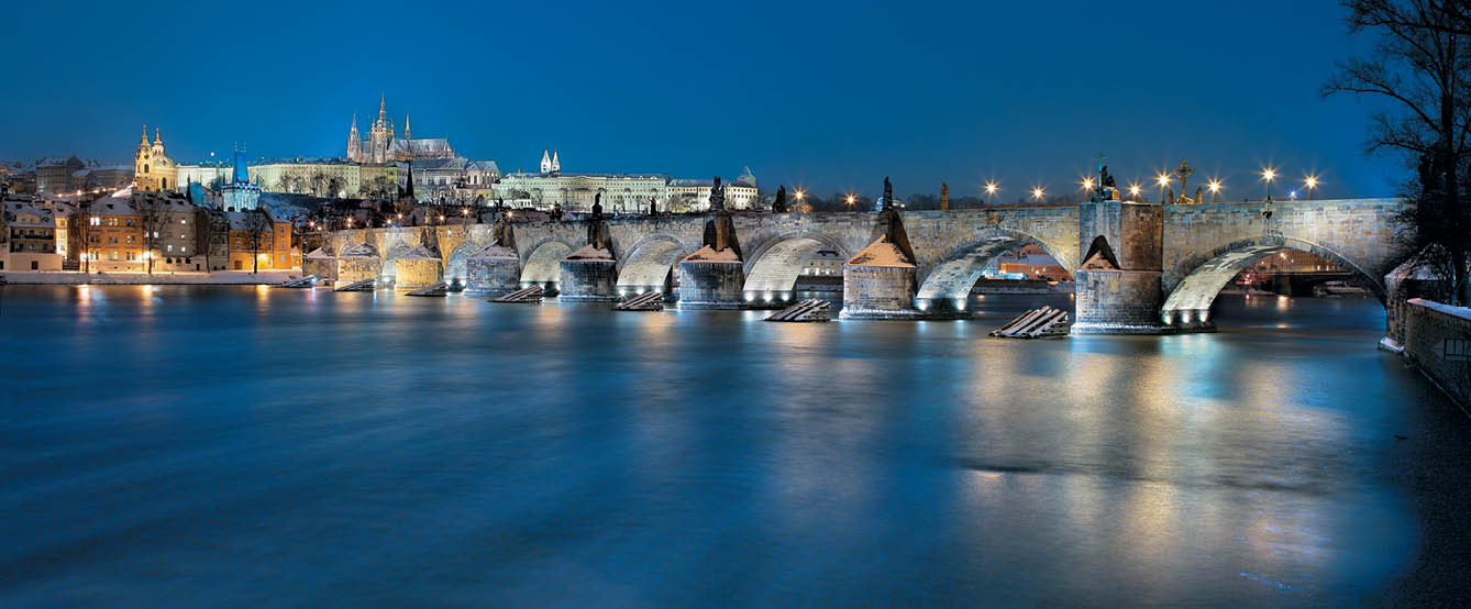 No n panorama m sta s osv tlen m historick m kamenn m mostem p es  eku a osv tlen mi budovami v pozad .  Popis generovan  AI