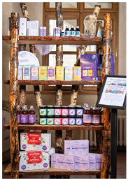 D ev n reg l s n kolika policemi obsahuj c  r zn  kosmetick  a wellness produkty v lahvi k ch, krabi k ch a tub ch um st n  v interi ru s oknem v pozad .  Popis generovan  AI